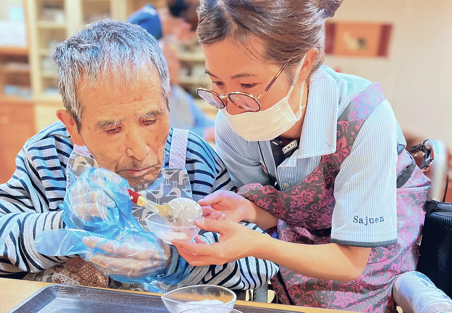 スタッフが利用者の食事をサポートしている様子