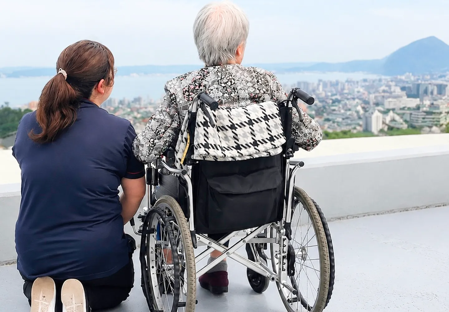 車椅子の利用者とスタッフが景色を眺めている様子